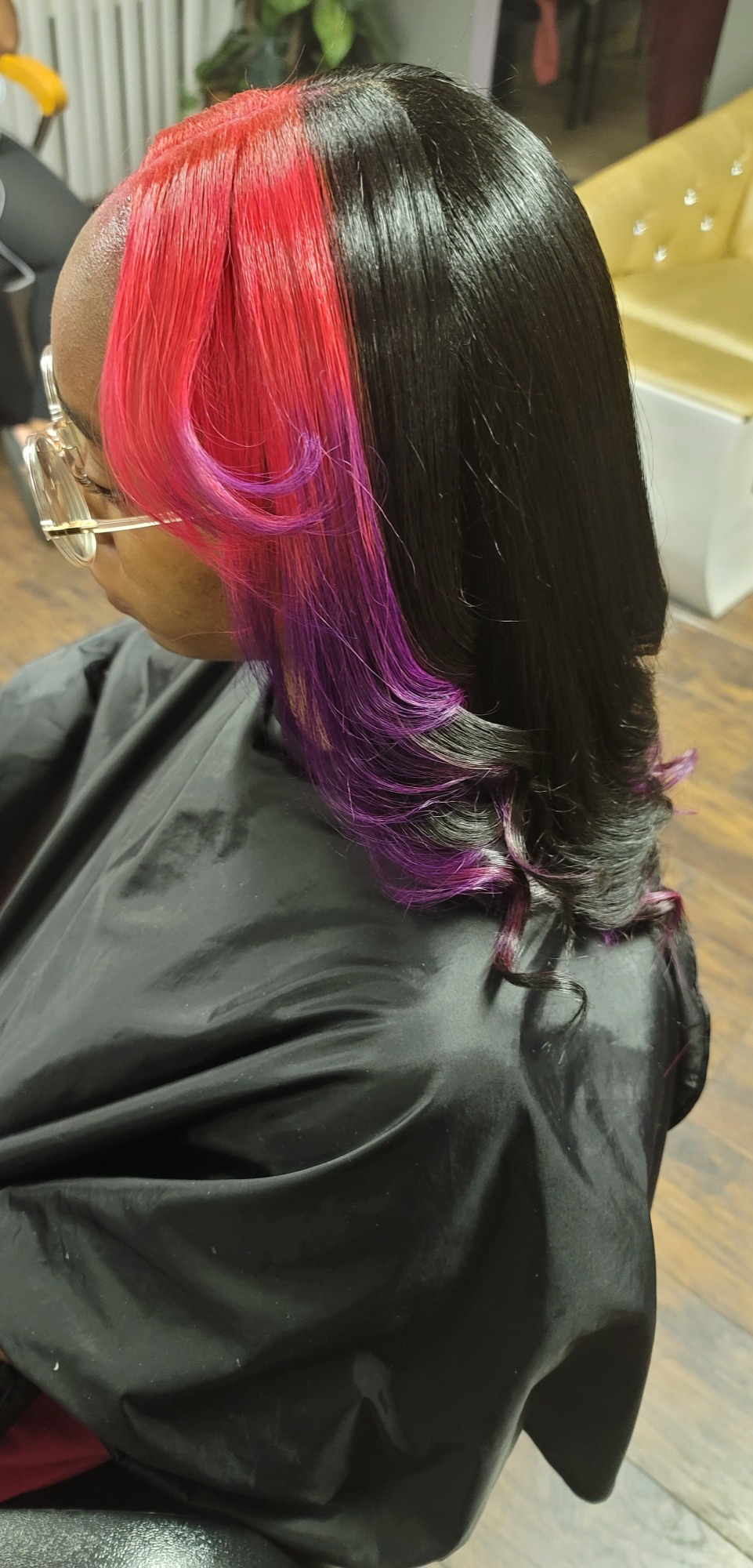 Hairstyle featuring vibrant red and purple highlights on dark hair.